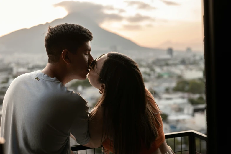 two people standing close together on the balcony