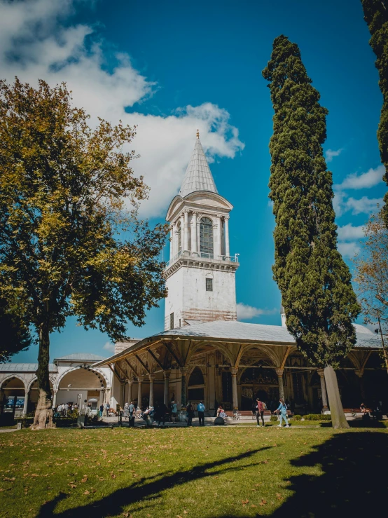 a white tower stands in front of two trees