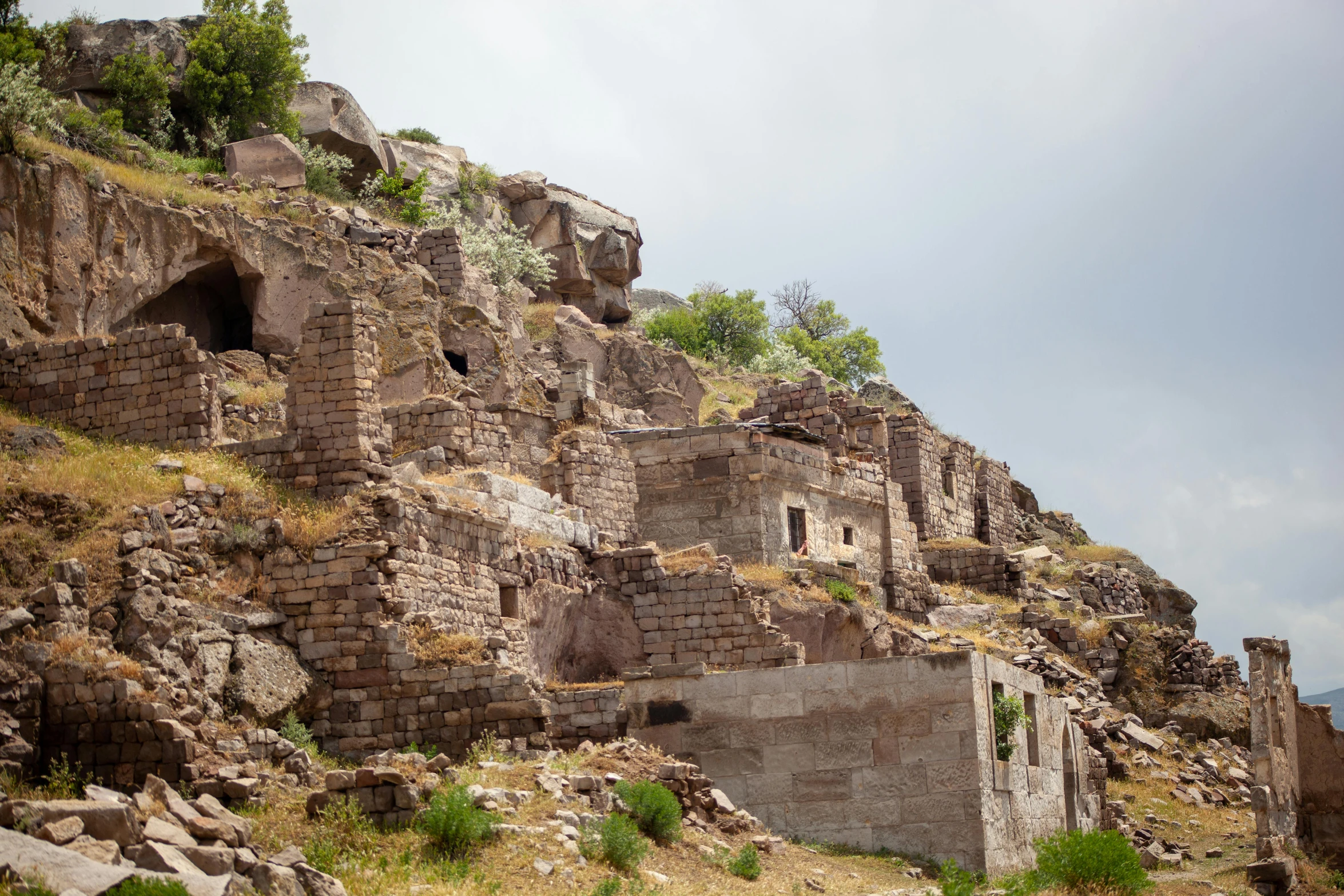 a cliff side building made of stone and grass