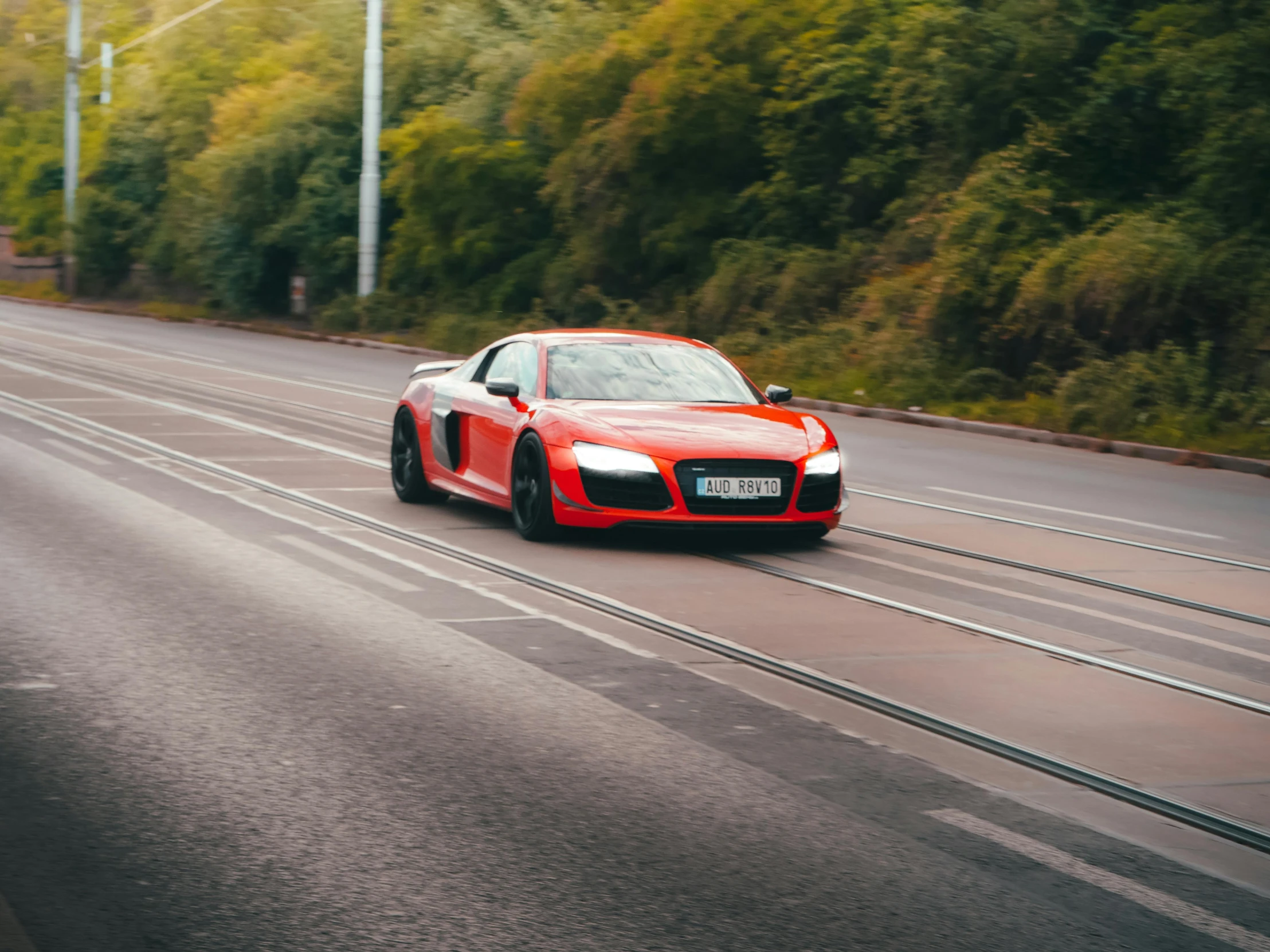 a red sports car driving down a street