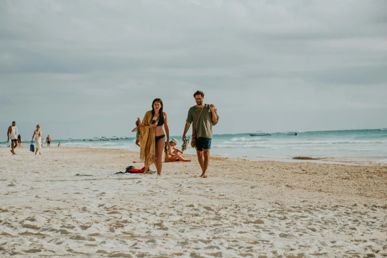 three adults and a child on the beach in sand