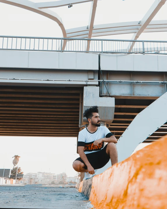 man squatting on the wall next to stairs