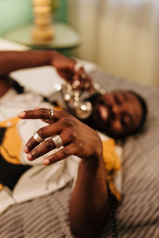 a woman lying on her stomach touching the end of a silver ring