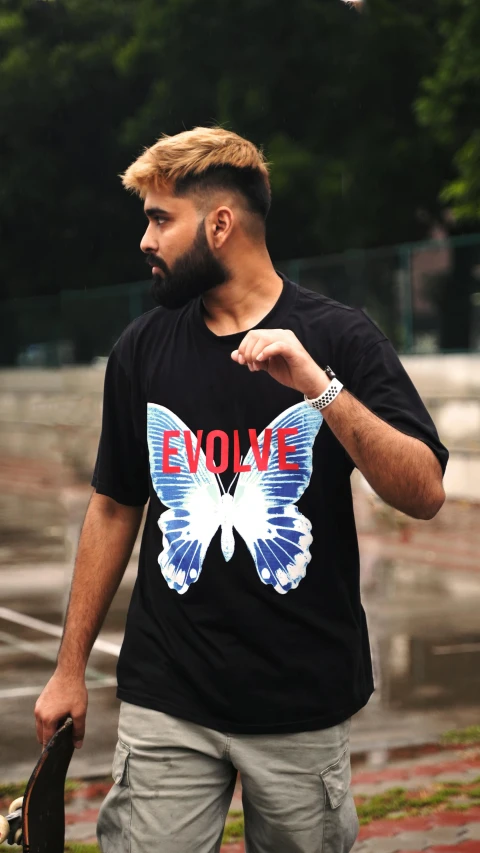 man wearing an evolite tee and grey pants with his hair styled into a comb