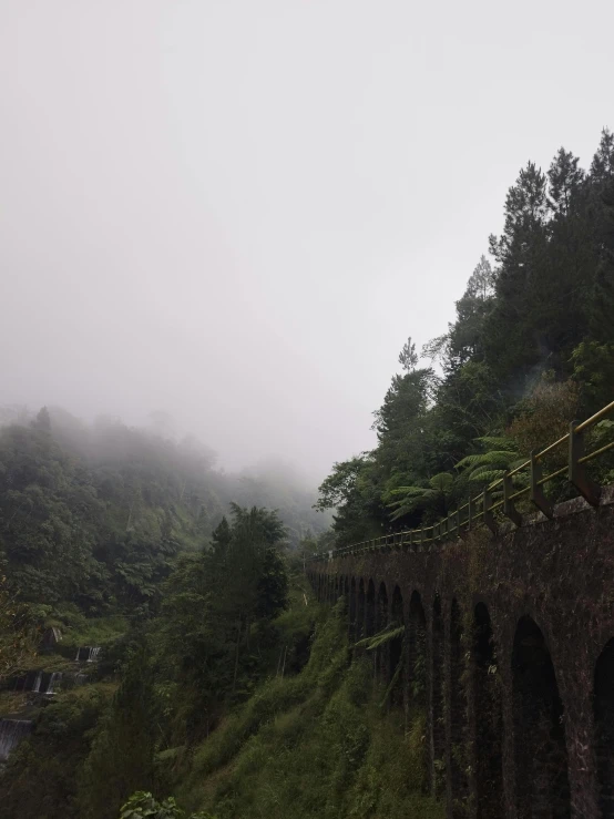 an old stone bridge on a foggy day