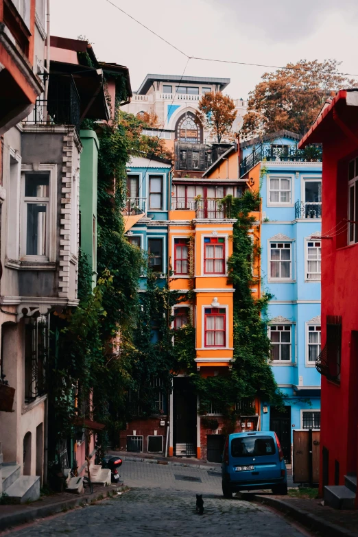 a car parked on the side of the road in front of several colored buildings