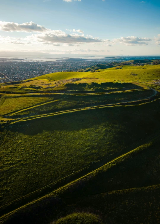 a green hill with yellow stripes and rolling green hills