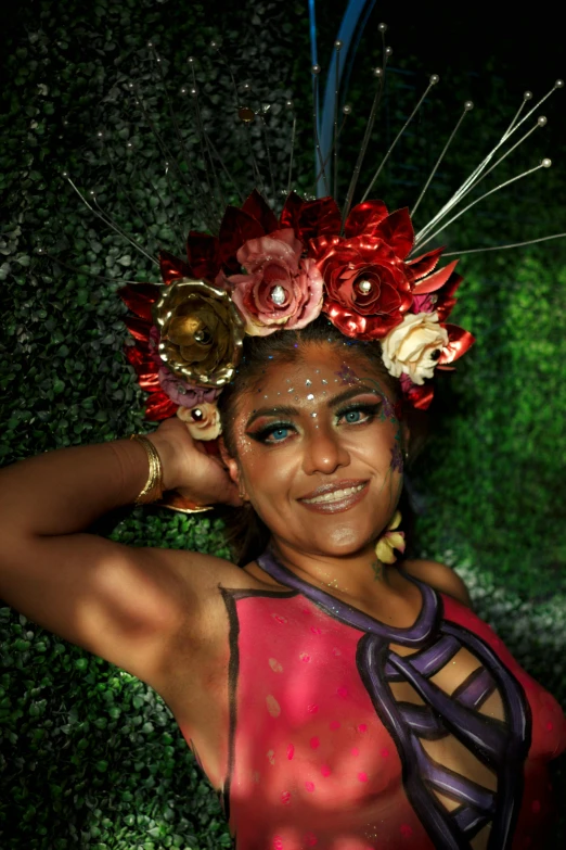 a woman in pink and purple with flowers on her head