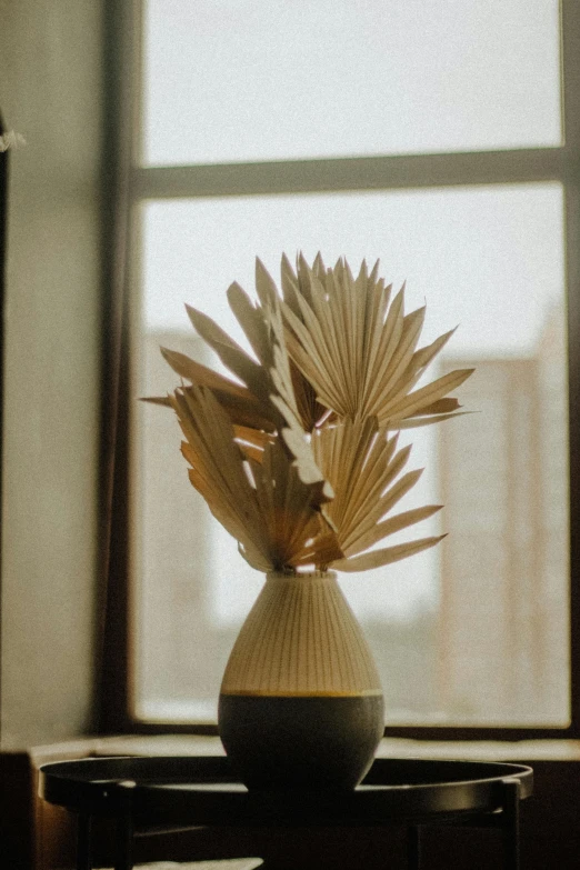 a vase with some white and yellow flowers in it