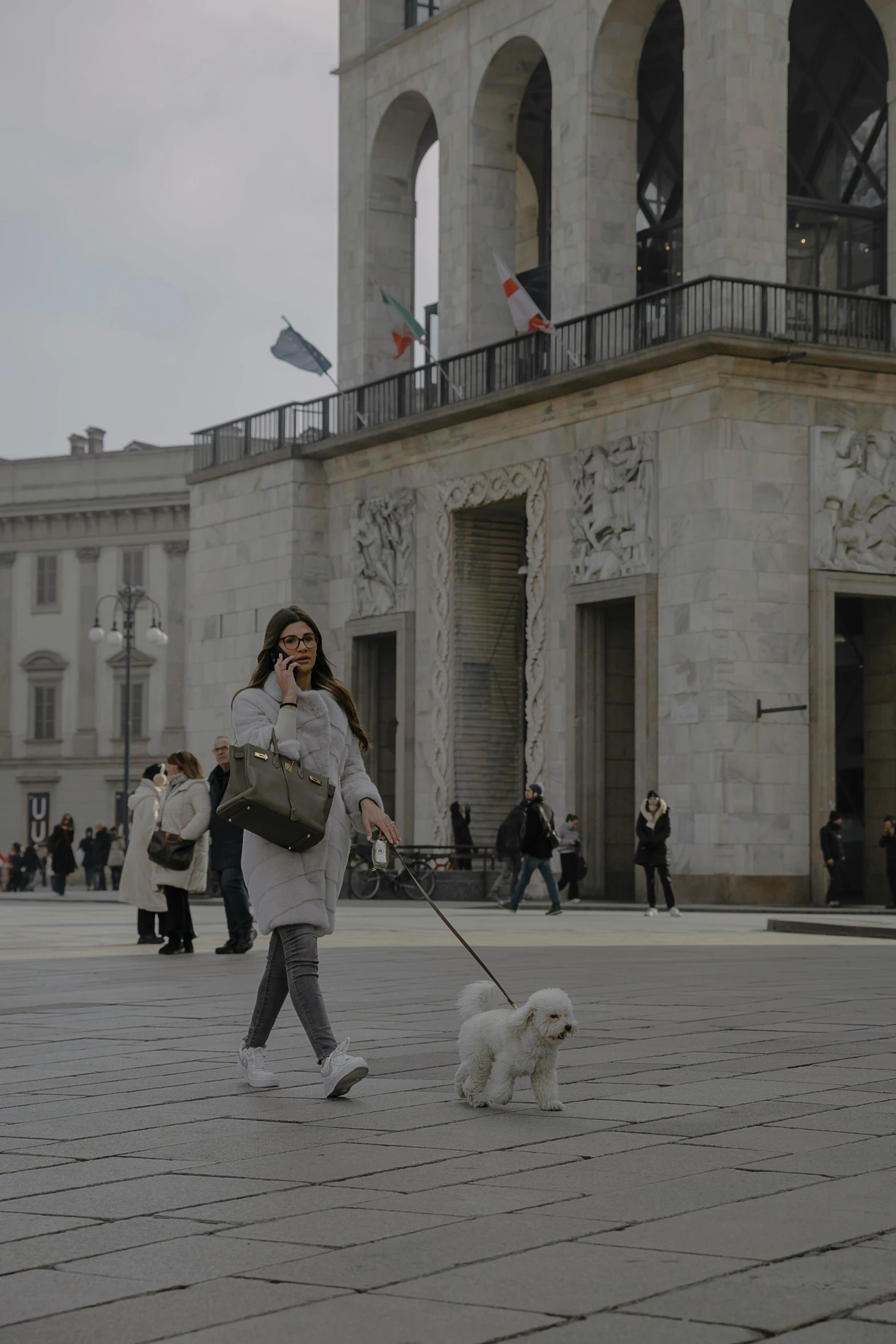 the woman is walking with two dogs on a leash