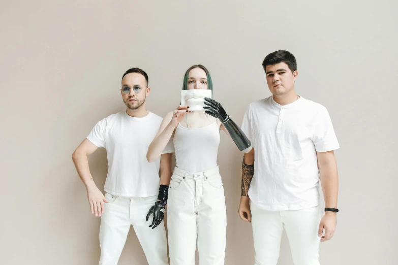 two men and one woman are standing behind two fake dolls