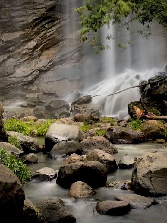 a stream flowing down a waterfall next to rocks