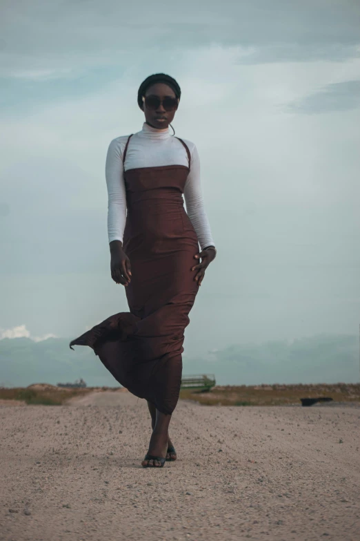 a woman wearing a brown and white dress with sunglasses