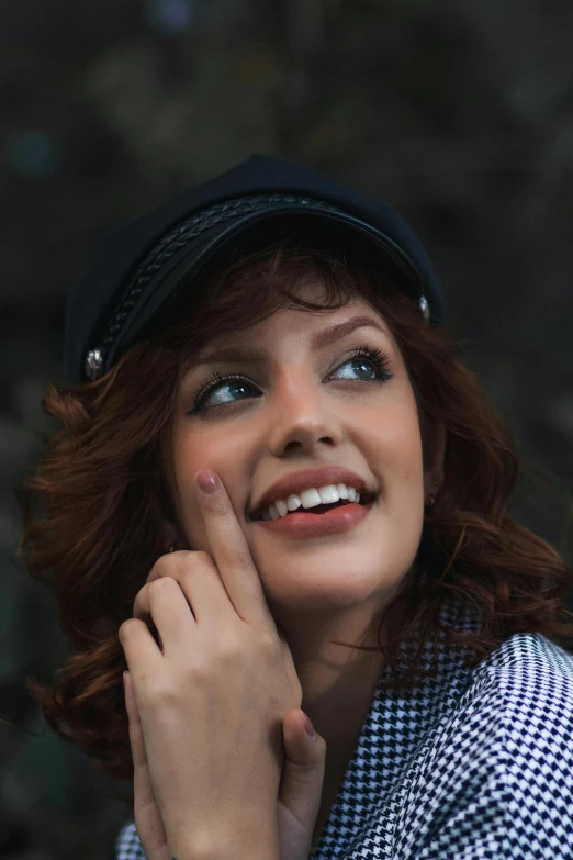 a young lady with red hair is wearing a hat and posing for the camera