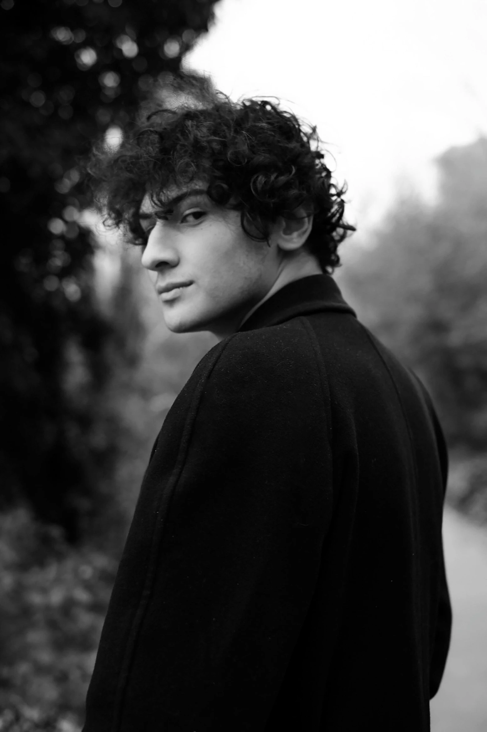 black and white po of young man with curly hair