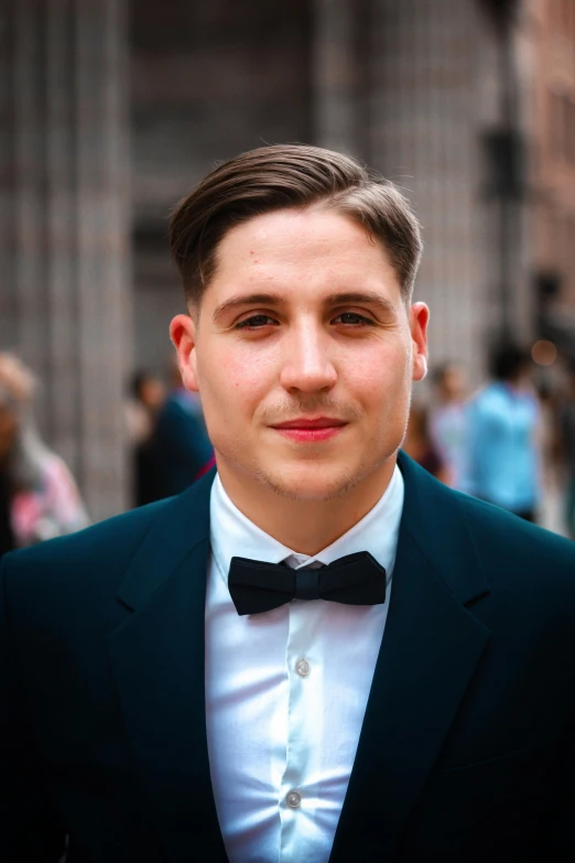 a young man dressed in a suit and bow tie