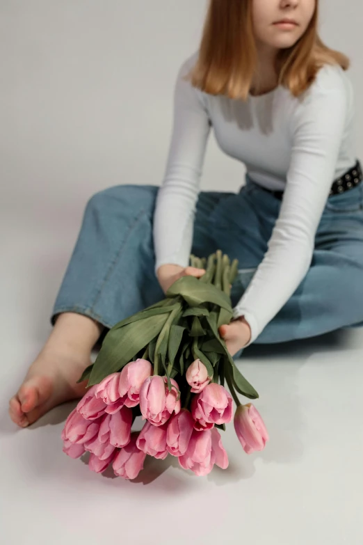 the  is sitting down with flowers on her leg