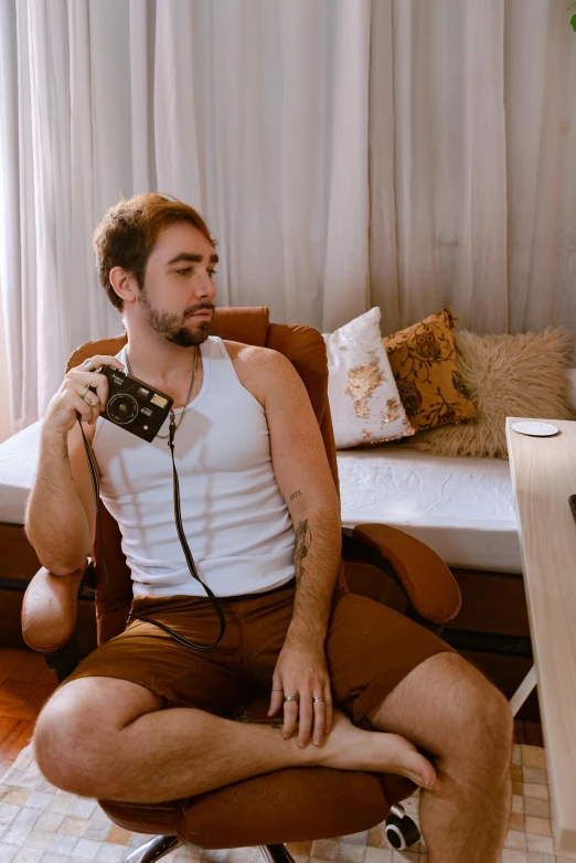 a young man sitting in front of a tv holding his camera