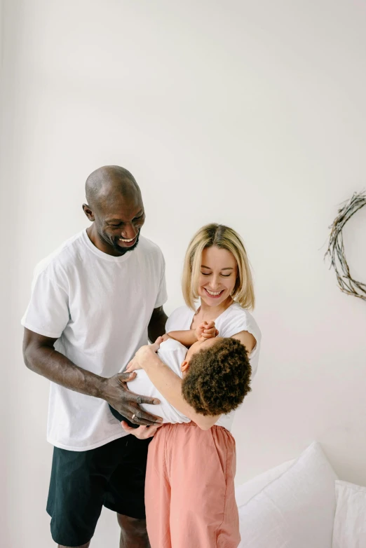 a man standing next to a child on top of a bed