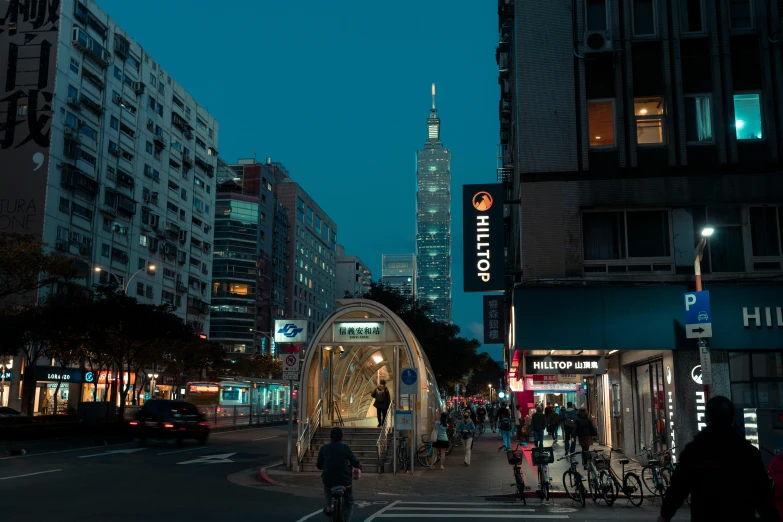 pedestrians walk around a city at night