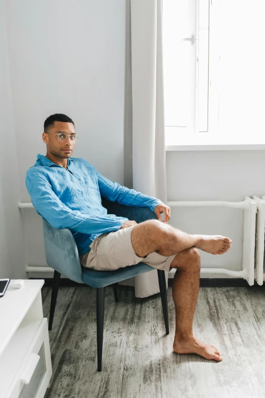 a man sitting on a chair in front of a window