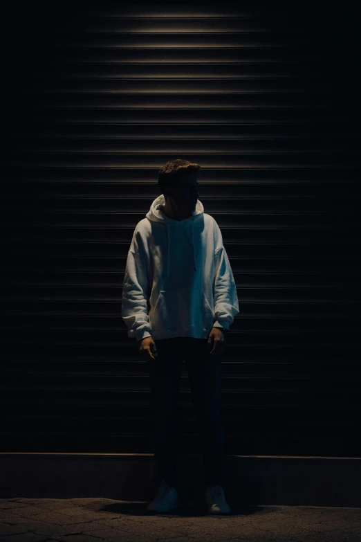 a man standing next to a building in the dark