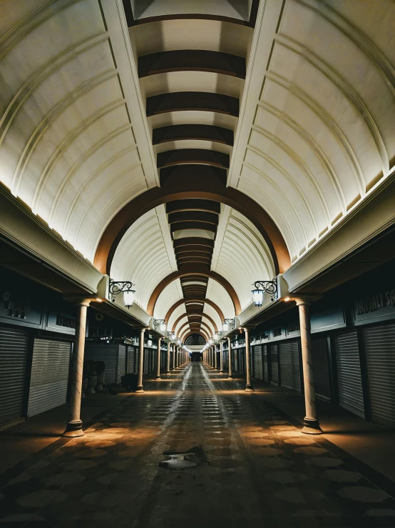 an empty corridor with many lights and shutters