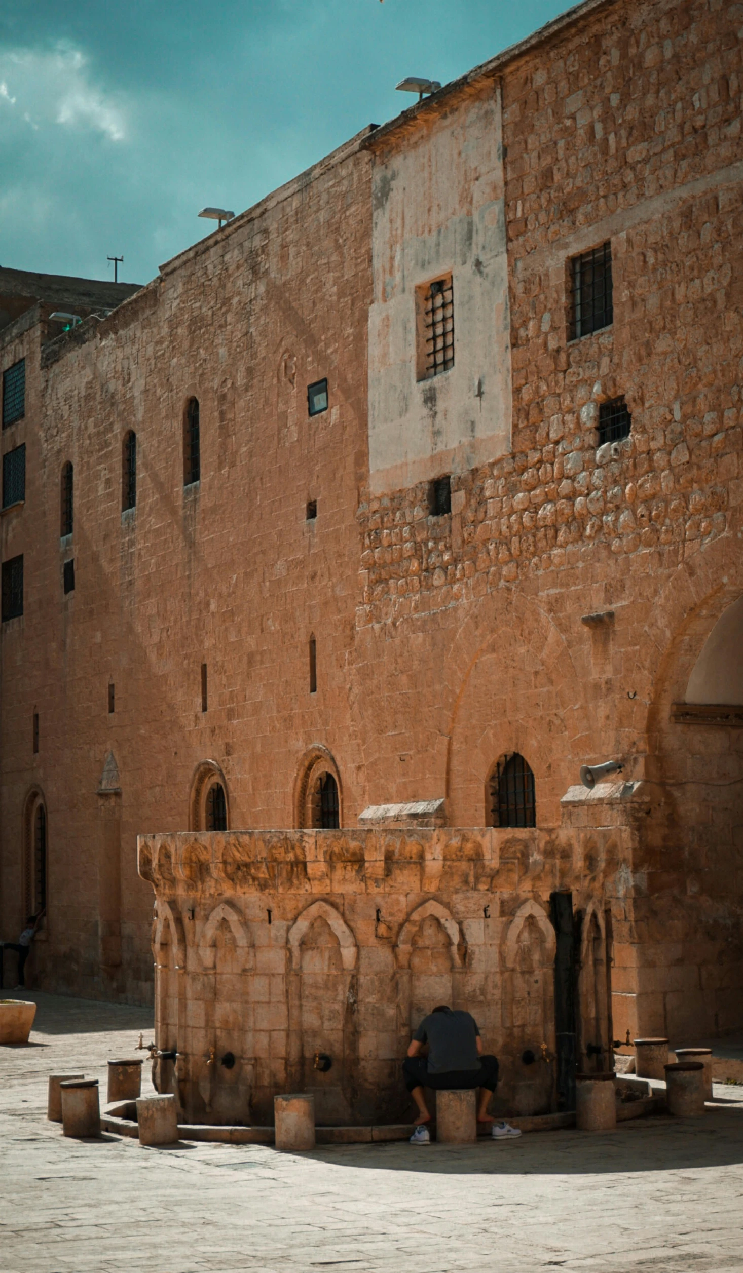 a guy in the courtyard looking into an old brick building