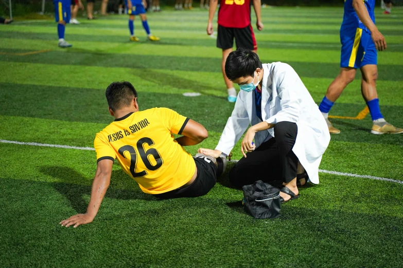 a person sitting on a soccer field during a game