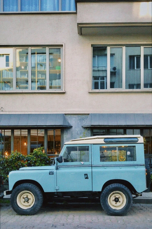 blue and white land rover car parked in front of a el