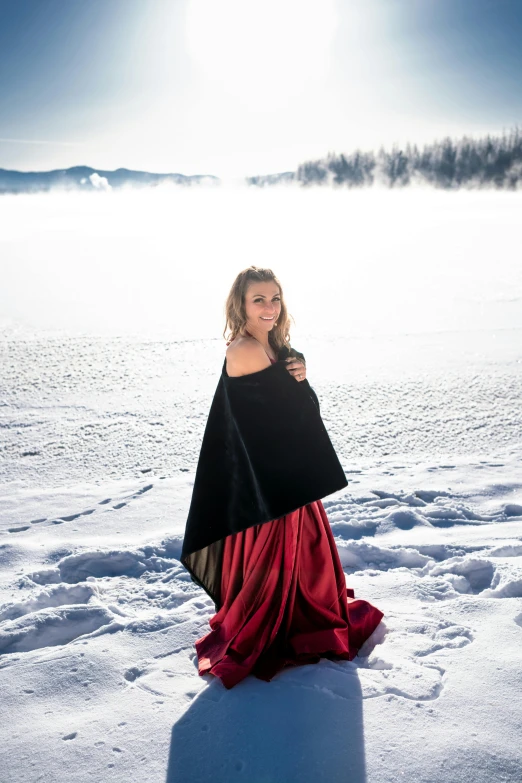 the woman in black and red is standing in the snow