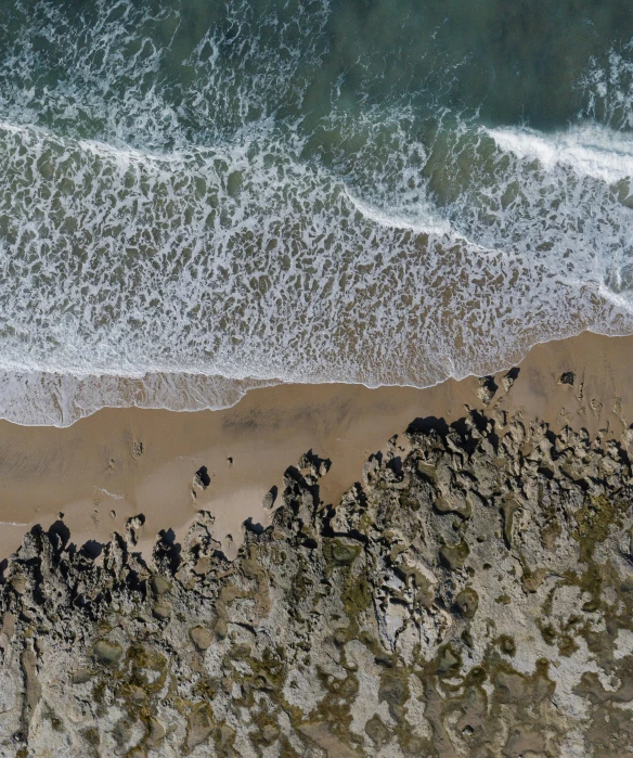 a bird view of the ocean water and rocks