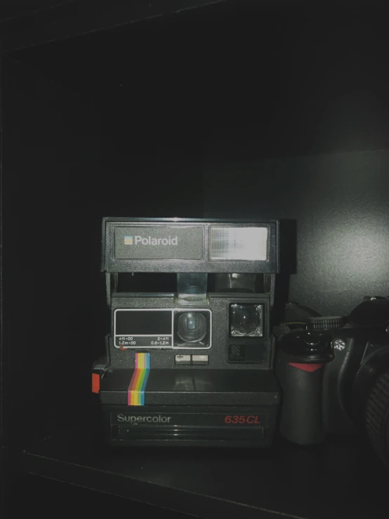 an old polaroid camera sitting on a shelf