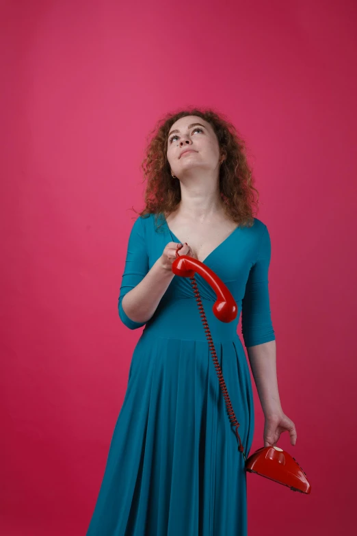 woman standing and holding a red phone in her hands