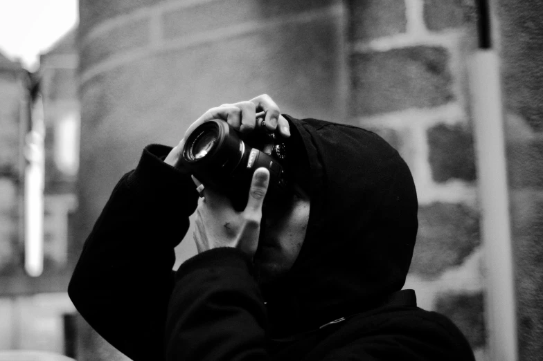 black and white pograph of a person holding up a camera