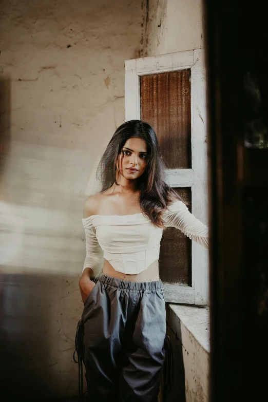 a beautiful woman standing next to a window in a room