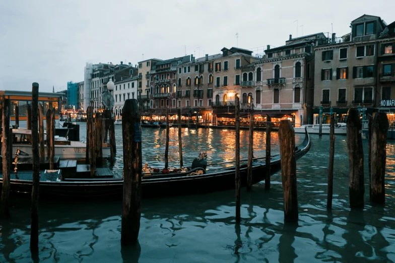 a boat is in the water near some buildings and lights