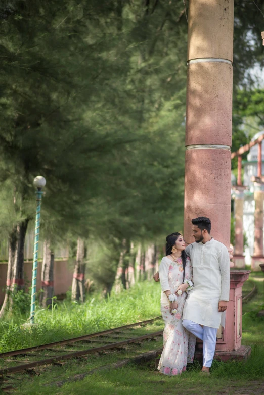 a couple is standing close together in front of some trees