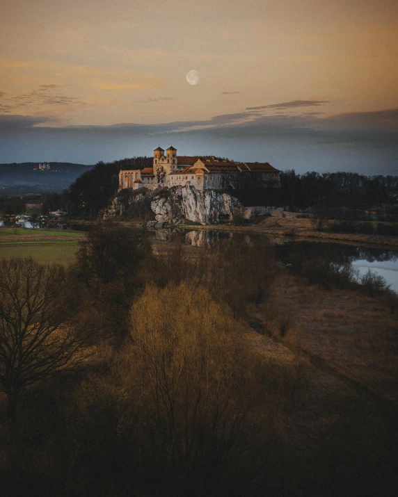 an old castle on a hill top with trees and grass