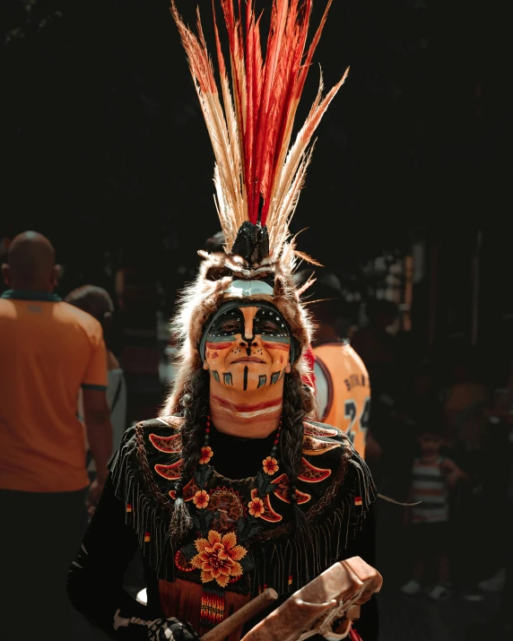 an indian tribe man with red feathers and headdress