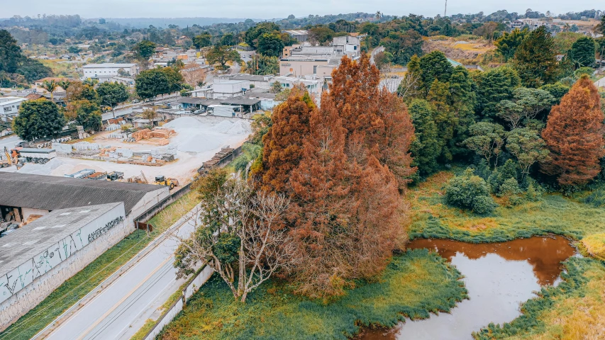 a river runs past houses with trees surrounding