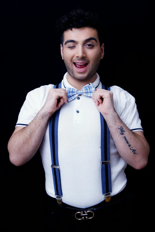 a man that is wearing a bow tie and suspenders