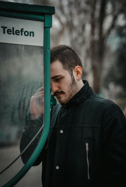 a man standing in front of a green sign