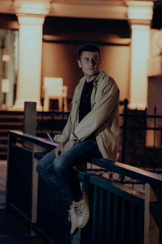 a man is posing for a po with a fence behind him