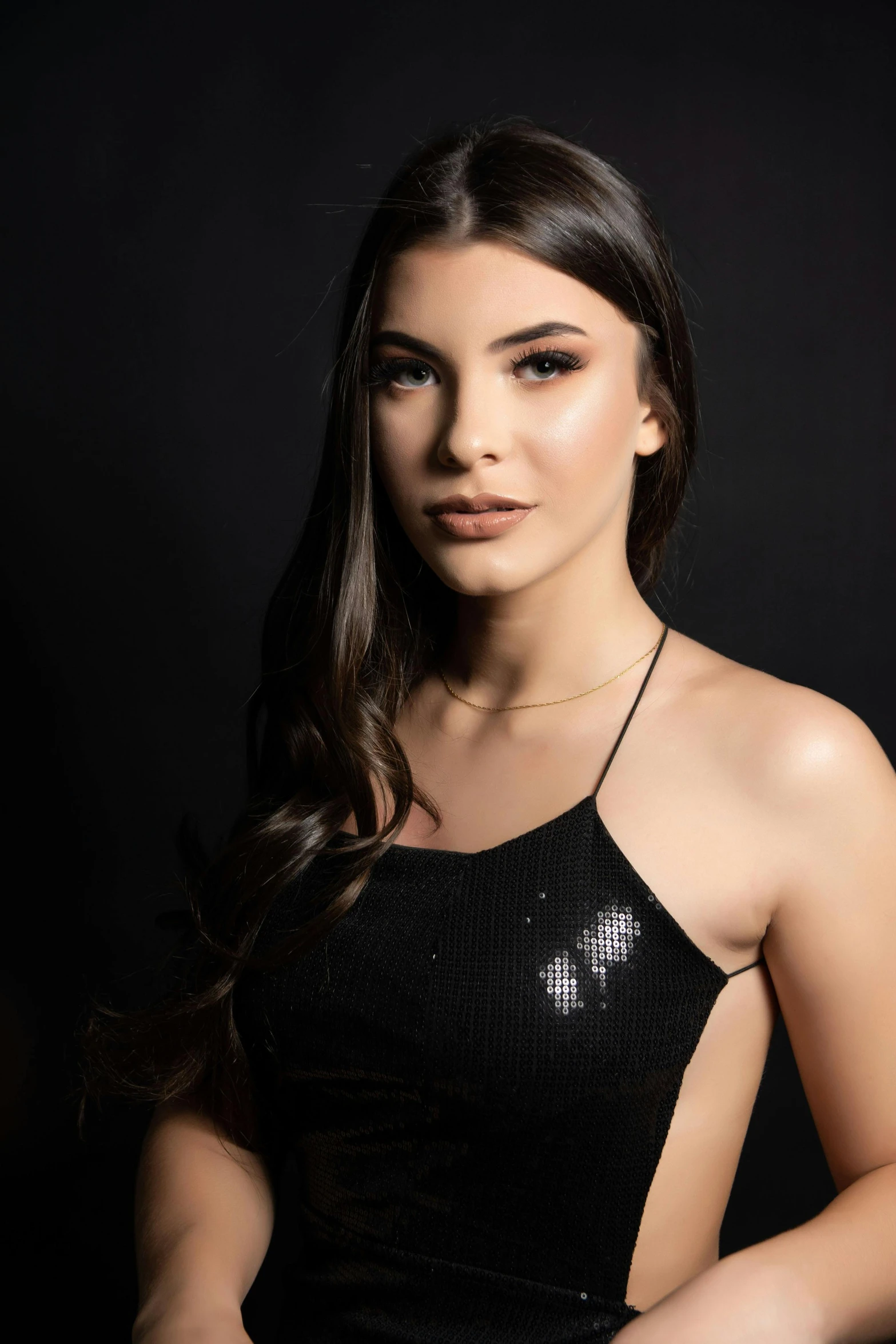 a young woman is wearing a black dress and posing for the camera