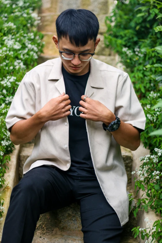 a man sitting on steps in the middle of bushes