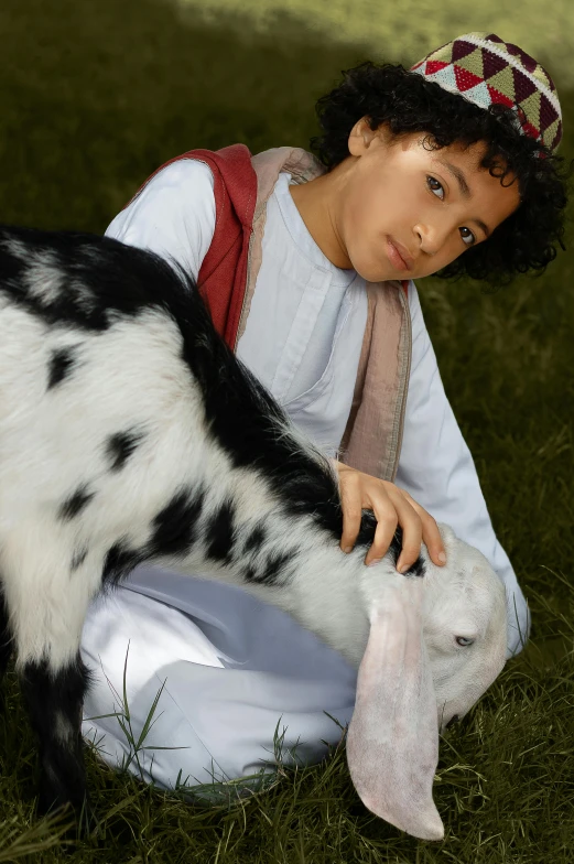 boy with goat skin is posing in the grass