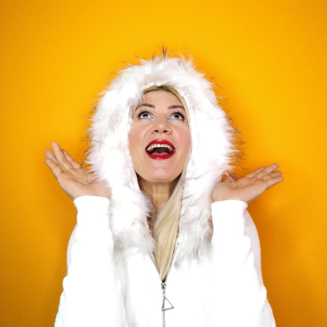 a lady wearing a white coat and wearing a hood with her hands on the hips