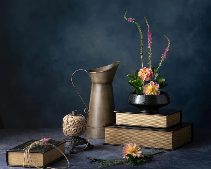 various objects displayed against a dark wall and floral arrangement