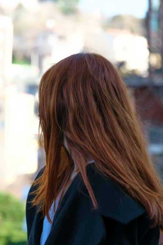 a woman with long red hair in a suit